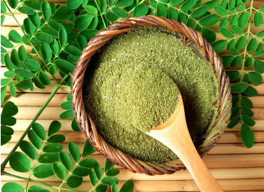 Image URL Text organic-moringa-powder-in-wooden-wire-bowl-with-wooden-spoon-and-fresh-moringa-leaves-placed-beside-on-bamboo-stick-wooden-table