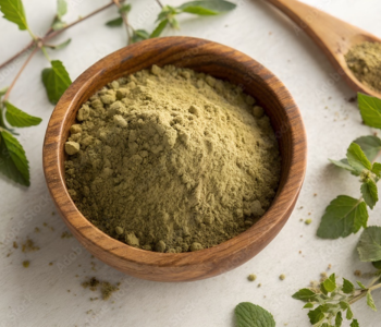Organic holy basil powder in a wooden bowl, surrounded by fresh tulsi leaves and flowers on a wooden table